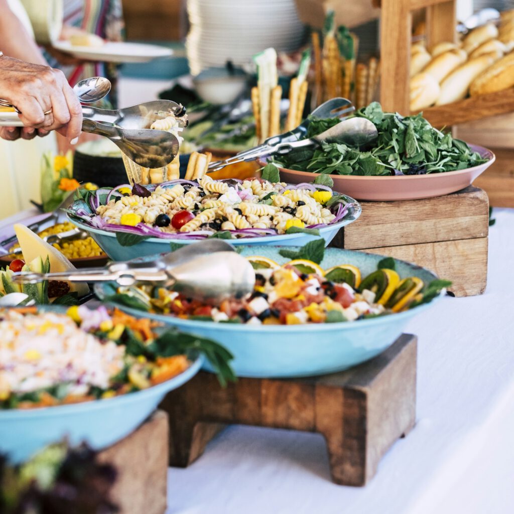 close up of view of table full of food with someone taking pasta of the table to celebrate